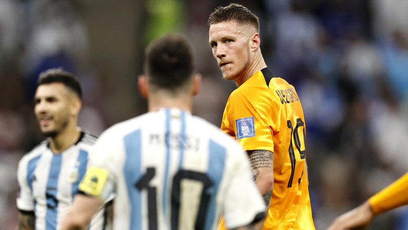 Penyerang #10 Argentina Lionel Messi (Tengah) berbicara dengan mantan pemain Belanda Edgar Davids saat ia merayakan kemenangan pertandingan sepak bola perempat final Piala Dunia Qatar 2022 antara Belanda dan Argentina di Stadion Lusail, utara Doha pada 9 Desember 2022. (FRANCK FIFE/AFP via Getty Images)