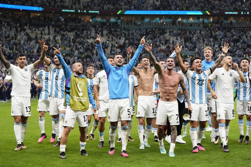 Penyerang #10 Argentina Lionel Messi (Tengah) berbicara dengan mantan pemain Belanda Edgar Davids saat ia merayakan kemenangan pertandingan sepak bola perempat final Piala Dunia Qatar 2022 antara Belanda dan Argentina di Stadion Lusail, utara Doha pada 9 Desember 2022. Penyerang #10 Argentina Lionel Messi (Tengah) berbicara dengan mantan pemain Belanda Edgar Davids saat ia merayakan kemenangan pertandingan sepak bola perempat final Piala Dunia Qatar 2022 antara Belanda dan Argentina di Stadion Lusail, utara Doha pada 9 Desember 2022. (FRANCK FIFE/AFP via Getty Images)