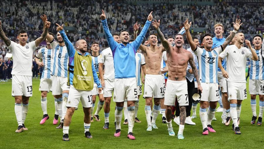 Penyerang #10 Argentina Lionel Messi (Tengah) berbicara dengan mantan pemain Belanda Edgar Davids saat ia merayakan kemenangan pertandingan sepak bola perempat final Piala Dunia Qatar 2022 antara Belanda dan Argentina di Stadion Lusail, utara Doha pada 9 Desember 2022. (FRANCK FIFE/AFP via Getty Images)