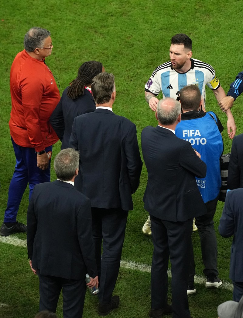 Penyerang #10 Argentina Lionel Messi (Tengah) berbicara dengan mantan pemain Belanda Edgar Davids saat ia merayakan kemenangan pertandingan sepak bola perempat final Piala Dunia Qatar 2022 antara Belanda dan Argentina di Stadion Lusail, utara Doha pada 9 Desember 2022. Penyerang #10 Argentina Lionel Messi (Tengah) berbicara dengan mantan pemain Belanda Edgar Davids saat ia merayakan kemenangan pertandingan sepak bola perempat final Piala Dunia Qatar 2022 antara Belanda dan Argentina di Stadion Lusail, utara Doha pada 9 Desember 2022. (FRANCK FIFE/AFP via Getty Images)