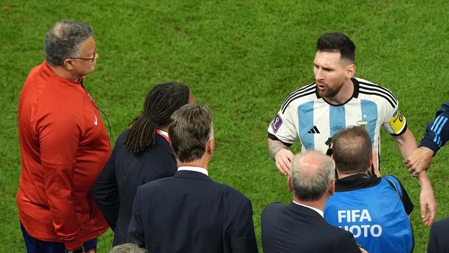 Penyerang #10 Argentina Lionel Messi (Tengah) berbicara dengan mantan pemain Belanda Edgar Davids saat ia merayakan kemenangan pertandingan sepak bola perempat final Piala Dunia Qatar 2022 antara Belanda dan Argentina di Stadion Lusail, utara Doha pada 9 Desember 2022. (FRANCK FIFE/AFP via Getty Images)
