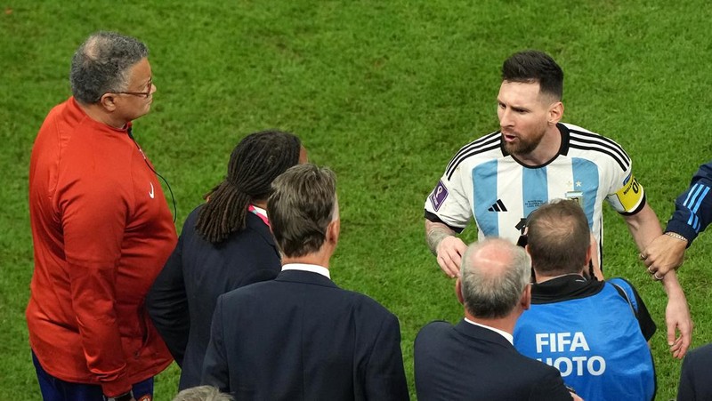 Penyerang #10 Argentina Lionel Messi (Tengah) berbicara dengan mantan pemain Belanda Edgar Davids saat ia merayakan kemenangan pertandingan sepak bola perempat final Piala Dunia Qatar 2022 antara Belanda dan Argentina di Stadion Lusail, utara Doha pada 9 Desember 2022. (FRANCK FIFE/AFP via Getty Images)