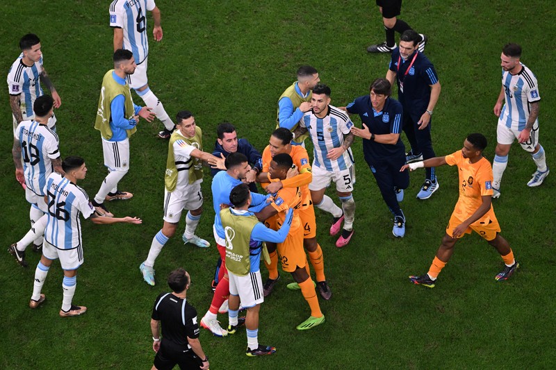 Penyerang #10 Argentina Lionel Messi (Tengah) berbicara dengan mantan pemain Belanda Edgar Davids saat ia merayakan kemenangan pertandingan sepak bola perempat final Piala Dunia Qatar 2022 antara Belanda dan Argentina di Stadion Lusail, utara Doha pada 9 Desember 2022. Penyerang #10 Argentina Lionel Messi (Tengah) berbicara dengan mantan pemain Belanda Edgar Davids saat ia merayakan kemenangan pertandingan sepak bola perempat final Piala Dunia Qatar 2022 antara Belanda dan Argentina di Stadion Lusail, utara Doha pada 9 Desember 2022. (FRANCK FIFE/AFP via Getty Images)