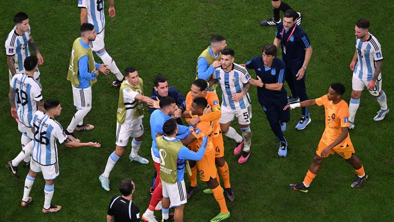 Penyerang #10 Argentina Lionel Messi (Tengah) berbicara dengan mantan pemain Belanda Edgar Davids saat ia merayakan kemenangan pertandingan sepak bola perempat final Piala Dunia Qatar 2022 antara Belanda dan Argentina di Stadion Lusail, utara Doha pada 9 Desember 2022. (FRANCK FIFE/AFP via Getty Images)