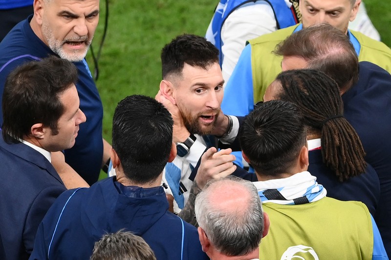 Penyerang #10 Argentina Lionel Messi (Tengah) berbicara dengan mantan pemain Belanda Edgar Davids saat ia merayakan kemenangan pertandingan sepak bola perempat final Piala Dunia Qatar 2022 antara Belanda dan Argentina di Stadion Lusail, utara Doha pada 9 Desember 2022. Penyerang #10 Argentina Lionel Messi (Tengah) berbicara dengan mantan pemain Belanda Edgar Davids saat ia merayakan kemenangan pertandingan sepak bola perempat final Piala Dunia Qatar 2022 antara Belanda dan Argentina di Stadion Lusail, utara Doha pada 9 Desember 2022. (FRANCK FIFE/AFP via Getty Images)