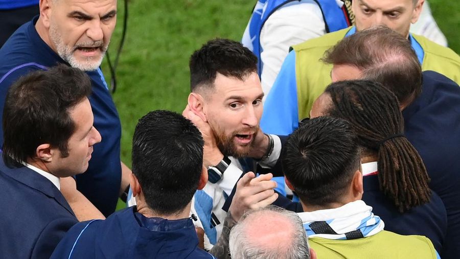 Penyerang #10 Argentina Lionel Messi (Tengah) berbicara dengan mantan pemain Belanda Edgar Davids saat ia merayakan kemenangan pertandingan sepak bola perempat final Piala Dunia Qatar 2022 antara Belanda dan Argentina di Stadion Lusail, utara Doha pada 9 Desember 2022. (FRANCK FIFE/AFP via Getty Images)