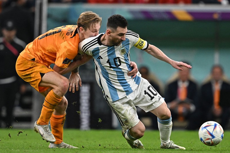 Penyerang #10 Argentina Lionel Messi (Tengah) berbicara dengan mantan pemain Belanda Edgar Davids saat ia merayakan kemenangan pertandingan sepak bola perempat final Piala Dunia Qatar 2022 antara Belanda dan Argentina di Stadion Lusail, utara Doha pada 9 Desember 2022. Penyerang #10 Argentina Lionel Messi (Tengah) berbicara dengan mantan pemain Belanda Edgar Davids saat ia merayakan kemenangan pertandingan sepak bola perempat final Piala Dunia Qatar 2022 antara Belanda dan Argentina di Stadion Lusail, utara Doha pada 9 Desember 2022. (FRANCK FIFE/AFP via Getty Images)