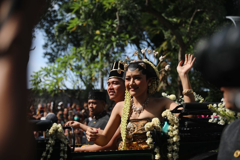 Pasangan pengantin baru Kaesang Pangarep dan Erina Gudono menjalani upacara kirab menggunakan kereta kencana di sepanjang Jalan Slamet Riyadi, Solo, Minggu (11/12/2022). (CNBC Indonesia/ Muhammad Sabki)