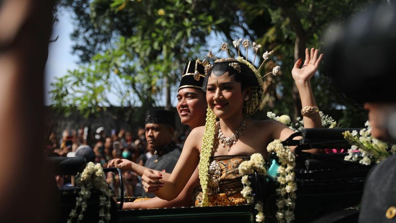 Pasangan pengantin baru Kaesang Pangarep dan Erina Gudono menjalani upacara kirab menggunakan kereta kencana di sepanjang Jalan Slamet Riyadi, Solo, Minggu (11/12/2022). (CNBC Indonesia/ Muhammad Sabki)