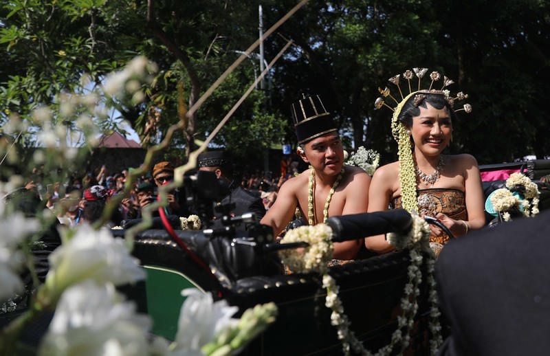 Pasangan pengantin baru Kaesang Pangarep dan Erina Gudono menjalani upacara kirab menggunakan kereta kencana di sepanjang Jalan Slamet Riyadi, Solo, Minggu (11/12/2022). (CNBC Indonesia/ Muhammad Sabki)