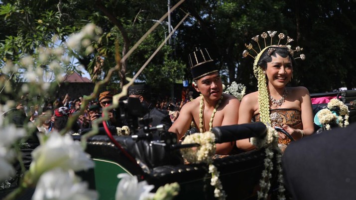 Pasangan pengantin baru Kaesang Pangarep dan Erina Gudono menjalani upacara kirab menggunakan kereta kencana di sepanjang Jalan Slamet Riyadi, Solo, Minggu (11/12/2022). (CNBC Indonesia/ Muhammad Sabki)