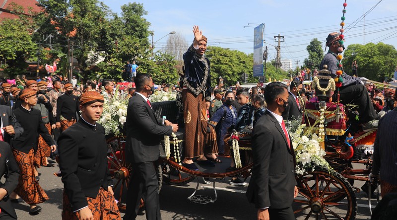 Pasangan pengantin baru Kaesang Pangarep dan Erina Gudono menjalani upacara kirab menggunakan kereta kencana di sepanjang Jalan Slamet Riyadi, Solo, Minggu (11/12/2022). Pasangan pengantin baru Kaesang Pangarep dan Erina Gudono menjalani upacara kirab menggunakan kereta kencana di sepanjang Jalan Slamet Riyadi, Solo, Minggu (11/12/2022). (CNBC Indonesia/ Muhammad Sabki)