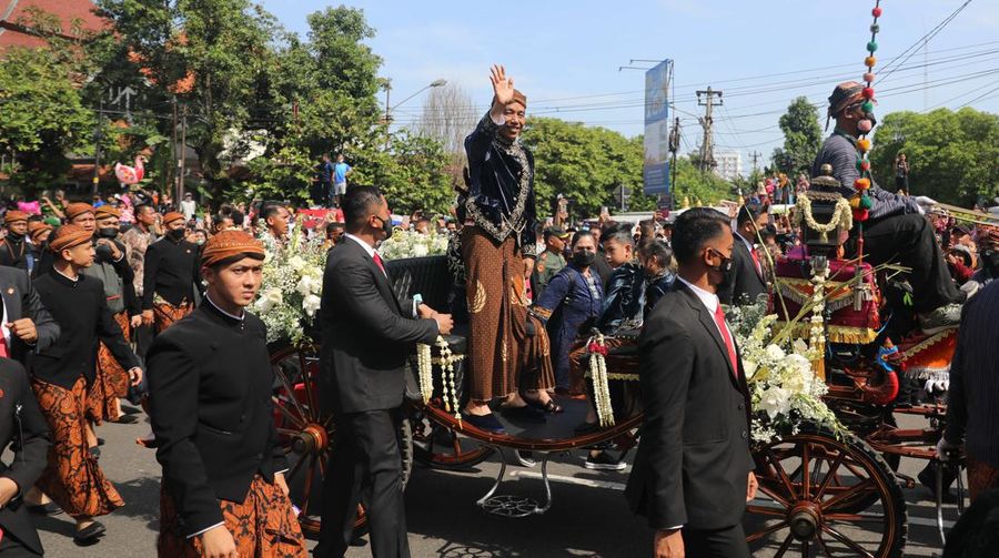 Pasangan pengantin baru Kaesang Pangarep dan Erina Gudono menjalani upacara kirab menggunakan kereta kencana di sepanjang Jalan Slamet Riyadi, Solo, Minggu (11/12/2022). (CNBC Indonesia/ Muhammad Sabki)