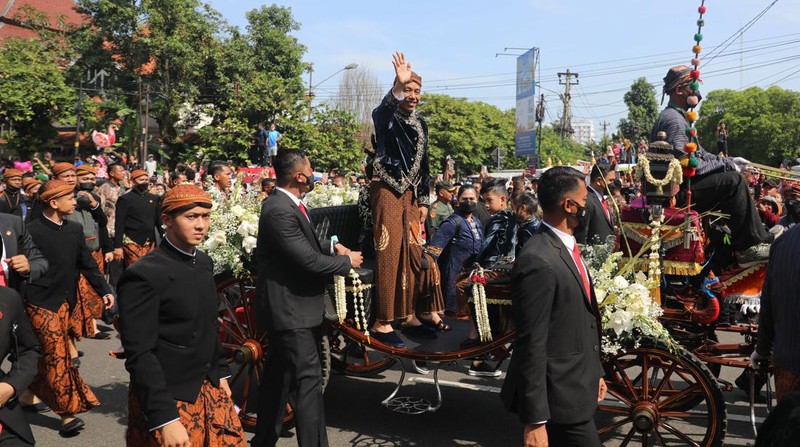 Pasangan pengantin baru Kaesang Pangarep dan Erina Gudono menjalani upacara kirab menggunakan kereta kencana di sepanjang Jalan Slamet Riyadi, Solo, Minggu (11/12/2022). (CNBC Indonesia/ Muhammad Sabki)