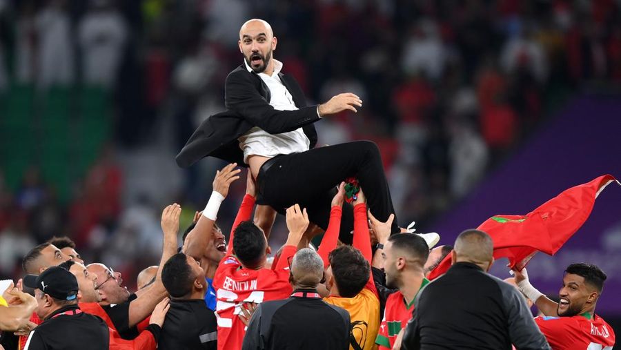 Walid Reragui, Pelatih Kepala Maroko, merayakan dengan tim mereka setelah kemenangan tim selama pertandingan perempat final Piala Dunia FIFA Qatar 2022 antara Maroko dan Portugal di Stadion Al Thumama pada 10 Desember 2022 di Doha, Qatar. (Photo by Justin Setterfield/Getty Images)