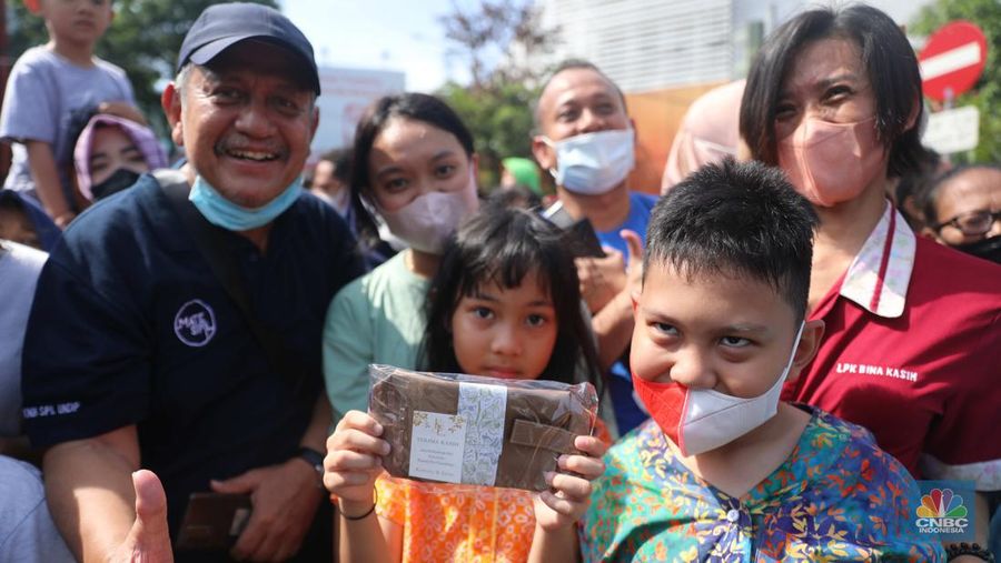 Warga berebut souvenir dari Kaesang Erina di Jalan Slamet Riyadi, Solo, Minggu, 11/12. Souvenir-souvenir tersebut membuat warga Solo yang beruntung menerima merasa sumringah. (CNBC Indonesia/ Muhammad Sabki)