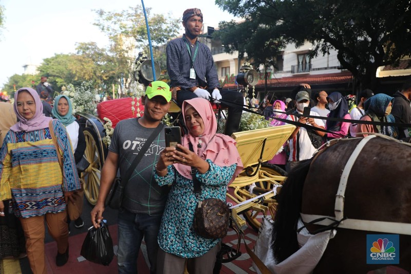 Warga berfoto di depan kereta kencana di Kawasan Car Free Day Slamet Riyadi, Solo, Jawa Tengah, Minggu (11/12). Kaesang Pangarep dan Erina Gudono akan menjalani ngunduh mantu dan tasyakuran hari ini. Acara ngunduh mantu dan tasyakuran Kaesang dan Erina. Warga berfoto di depan kereta kencana di Kawasan Car Free Day Slamet Riyadi, Solo, Jawa Tengah, Minggu (11/12). Kaesang Pangarep dan Erina Gudono akan menjalani ngunduh mantu dan tasyakuran hari ini. Acara ngunduh mantu dan tasyakuran Kaesang dan Erina. (CNBC Indonesia/ Muhammad Sabki)