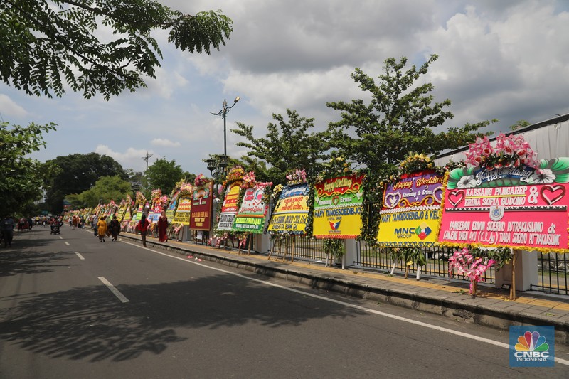 Warga melintas di depan karangan bunga ucapan selamat atas pernikahan Kaesang Pangarep dengan Erina Gudono di depan Pura Mangkunegaran, Solo, Minggu, 11/12. Ratusan karangan bunga ucapan selamat atas pernikahan Kaesang-Erina dikirimkan sejumlah karangan. Warga melintas di depan karangan bunga ucapan selamat atas pernikahan Kaesang Pangarep dengan Erina Gudono di depan Pura Mangkunegaran, Solo, Minggu, 11/12. Ratusan karangan bunga ucapan selamat atas pernikahan Kaesang-Erina dikirimkan sejumlah karangan. (CNBC Indonesia/ Muhammad Sabki)