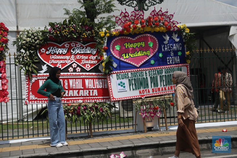 Warga melintas di depan karangan bunga ucapan selamat atas pernikahan Kaesang Pangarep dengan Erina Gudono di depan Pura Mangkunegaran, Solo, Minggu, 11/12. Ratusan karangan bunga ucapan selamat atas pernikahan Kaesang-Erina dikirimkan sejumlah karangan. Warga melintas di depan karangan bunga ucapan selamat atas pernikahan Kaesang Pangarep dengan Erina Gudono di depan Pura Mangkunegaran, Solo, Minggu, 11/12. Ratusan karangan bunga ucapan selamat atas pernikahan Kaesang-Erina dikirimkan sejumlah karangan. (CNBC Indonesia/ Muhammad Sabki)