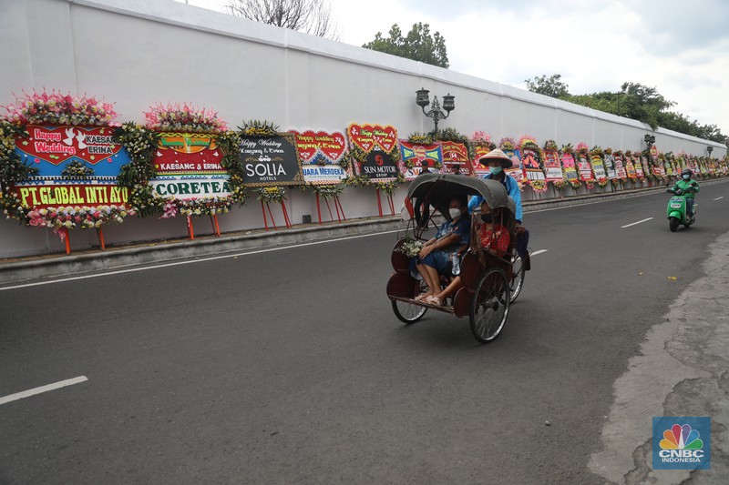Warga melintas di depan karangan bunga ucapan selamat atas pernikahan Kaesang Pangarep dengan Erina Gudono di depan Pura Mangkunegaran, Solo, Minggu, 11/12. Ratusan karangan bunga ucapan selamat atas pernikahan Kaesang-Erina dikirimkan sejumlah karangan. Warga melintas di depan karangan bunga ucapan selamat atas pernikahan Kaesang Pangarep dengan Erina Gudono di depan Pura Mangkunegaran, Solo, Minggu, 11/12. Ratusan karangan bunga ucapan selamat atas pernikahan Kaesang-Erina dikirimkan sejumlah karangan. (CNBC Indonesia/ Muhammad Sabki)