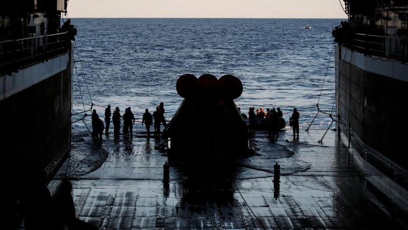 Kapsul Orion NASA berjalan menuju USS Portland (LPD 27) setelah berhasil diamankan oleh tim NASA dan Angkatan Laut AS di lepas pantai Baja California, Meksiko, pada 11 Desember 2022. - Orion diluncurkan 16 November dengan roket Artemis untuk misi 25 hari ke Bulan. Tujuan utama dari misi ini adalah untuk menguji pelindung panas Orion apa cocok untuk manusia berada di dalamnya. (CAROLINE BREHMAN/POOL/AFP via Getty Images)