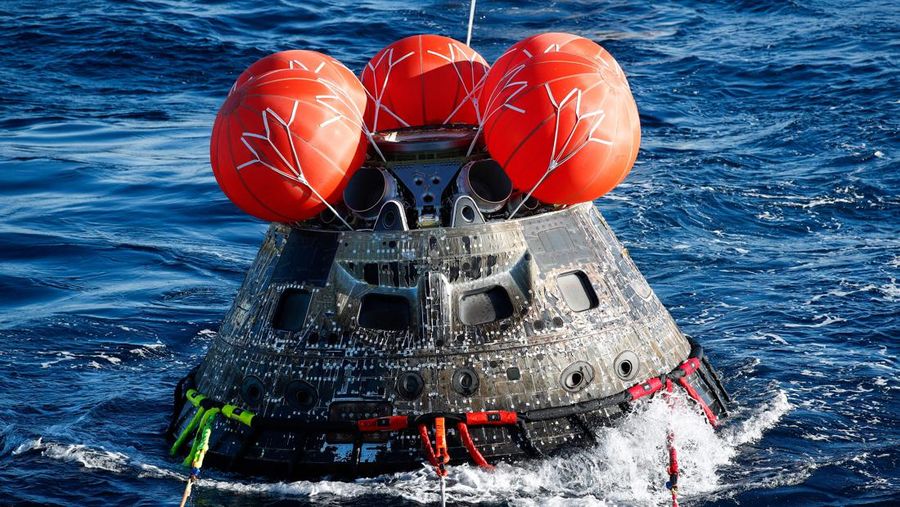 Kapsul Orion NASA berjalan menuju USS Portland (LPD 27) setelah berhasil diamankan oleh tim NASA dan Angkatan Laut AS di lepas pantai Baja California, Meksiko, pada 11 Desember 2022. - Orion diluncurkan 16 November dengan roket Artemis untuk misi 25 hari ke Bulan. Tujuan utama dari misi ini adalah untuk menguji pelindung panas Orion apa cocok untuk manusia berada di dalamnya. (CAROLINE BREHMAN/POOL/AFP via Getty Images)