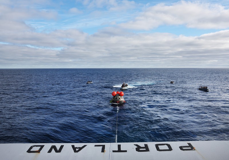 Kapsul Orion NASA berjalan menuju USS Portland (LPD 27) setelah berhasil diamankan oleh tim NASA dan Angkatan Laut AS di lepas pantai Baja California, Meksiko, pada 11 Desember 2022. - Orion diluncurkan 16 November dengan roket Artemis untuk misi 25 hari ke Bulan. Tujuan utama dari misi ini adalah untuk menguji pelindung panas Orion apa cocok untuk manusia berada di dalamnya. (CAROLINE BREHMAN/POOL/AFP via Getty Images)