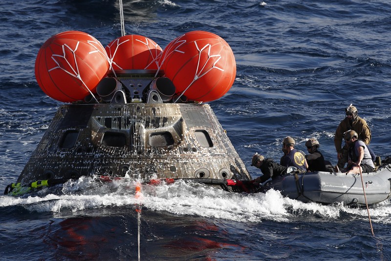 Kapsul Orion NASA berjalan menuju USS Portland (LPD 27) setelah berhasil diamankan oleh tim NASA dan Angkatan Laut AS di lepas pantai Baja California, Meksiko, pada 11 Desember 2022. Kapsul Orion NASA berjalan menuju USS Portland (LPD 27) setelah berhasil diamankan oleh tim NASA dan Angkatan Laut AS di lepas pantai Baja California, Meksiko, pada 11 Desember 2022. - Orion diluncurkan 16 November dengan roket Artemis untuk misi 25 hari ke Bulan. Tujuan utama dari misi ini adalah untuk menguji pelindung panas Orion apa cocok untuk manusia berada di dalamnya. (CAROLINE BREHMAN/POOL/AFP via Getty Images)
