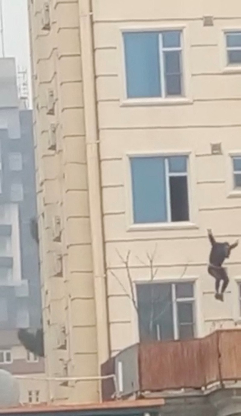 AFGHANISTAN-SHOOTING/UGC A person prepares to jump from a hotel window in Shahr-e-Naw neighborhood amid sounds of gunfire in Kabul, Afghanistan December 12, 2022 in this still image from video. Aamaj News via REUTERS THIS IMAGE HAS BEEN SUPPLIED BY A THIRD PARTY. NO RESALES. NO ARCHIVES. MANDATORY CREDIT