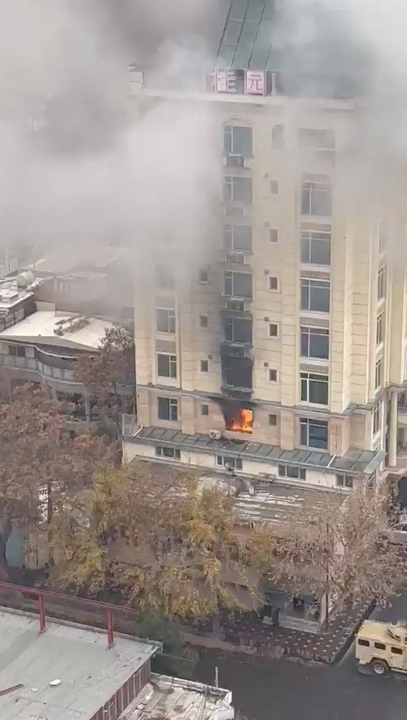 A person prepares to jump from a hotel window in Shahr-e-Naw neighborhood amid sounds of gunfire in Kabul, Afghanistan December 12, 2022 in this still image from video. Aamaj News via REUTERS  THIS IMAGE HAS BEEN SUPPLIED BY A THIRD PARTY. NO RESALES. NO ARCHIVES. MANDATORY CREDIT