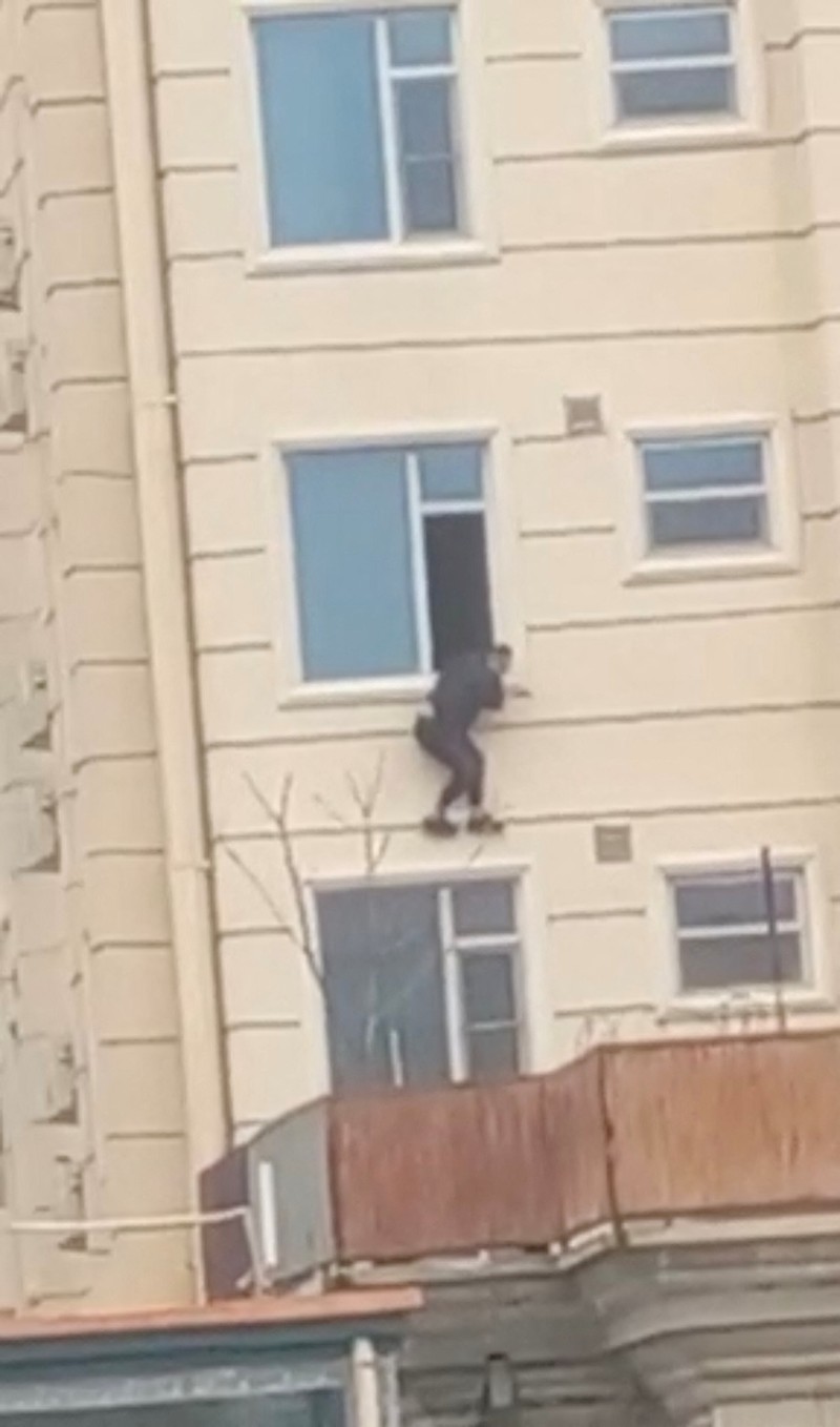 AFGHANISTAN-SHOOTING/UGC A person prepares to jump from a hotel window in Shahr-e-Naw neighborhood amid sounds of gunfire in Kabul, Afghanistan December 12, 2022 in this still image from video. Aamaj News via REUTERS THIS IMAGE HAS BEEN SUPPLIED BY A THIRD PARTY. NO RESALES. NO ARCHIVES. MANDATORY CREDIT