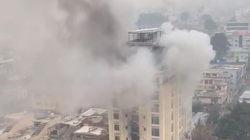 A person prepares to jump from a hotel window in Shahr-e-Naw neighborhood amid sounds of gunfire in Kabul, Afghanistan December 12, 2022 in this still image from video. Aamaj News via REUTERS  THIS IMAGE HAS BEEN SUPPLIED BY A THIRD PARTY. NO RESALES. NO ARCHIVES. MANDATORY CREDIT