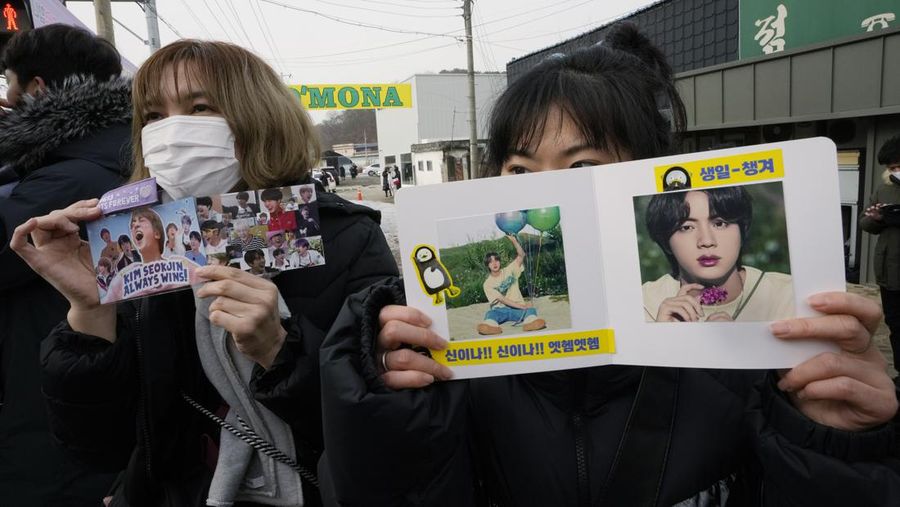 Fans wait for K-pop band BTS's member Jin to arrive before he enters the army to serve near an army training center in Yeoncheon, South Korea, Tuesday, Dec. 13, 2022. Jin, the oldest member of K-pop supergroup BTS, was set to enter a frontline South Korean boot camp Tuesday to start his 18 months of mandatory military service, as fans gathered near the base to say goodbye to their star. (AP Photo/Ahn Young-joon)