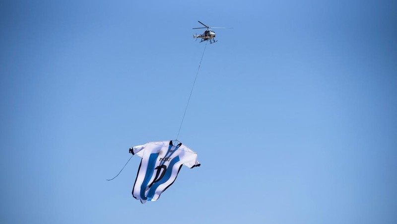 Helikopter membawa t-shirt raksasa penyerang Argentina Lionel Messi di atas Rosario, Argentina, pada 13 Desember 2022, sebelum pertandingan sepak bola semifinal Piala Dunia Qatar 2022 antara Argentina dan Kroasia. (AFP via Getty Images/STR)