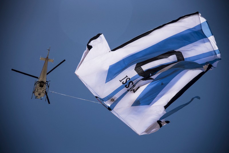 Helikopter membawa t-shirt raksasa penyerang Argentina Lionel Messi di atas Rosario, Argentina, pada 13 Desember 2022, sebelum pertandingan sepak bola semifinal Piala Dunia Qatar 2022 antara Argentina dan Kroasia. (AFP via Getty Images/STR) Helikopter membawa t-shirt raksasa penyerang Argentina Lionel Messi di atas Rosario, Argentina, pada 13 Desember 2022, sebelum pertandingan sepak bola semifinal Piala Dunia Qatar 2022 antara Argentina dan Kroasia. (AFP via Getty Images/STR)