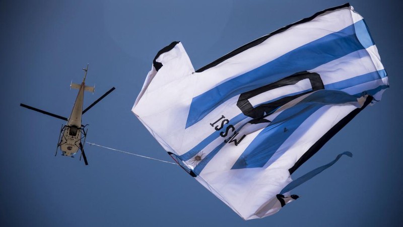 Helikopter membawa t-shirt raksasa penyerang Argentina Lionel Messi di atas Rosario, Argentina, pada 13 Desember 2022, sebelum pertandingan sepak bola semifinal Piala Dunia Qatar 2022 antara Argentina dan Kroasia. (AFP via Getty Images/STR)