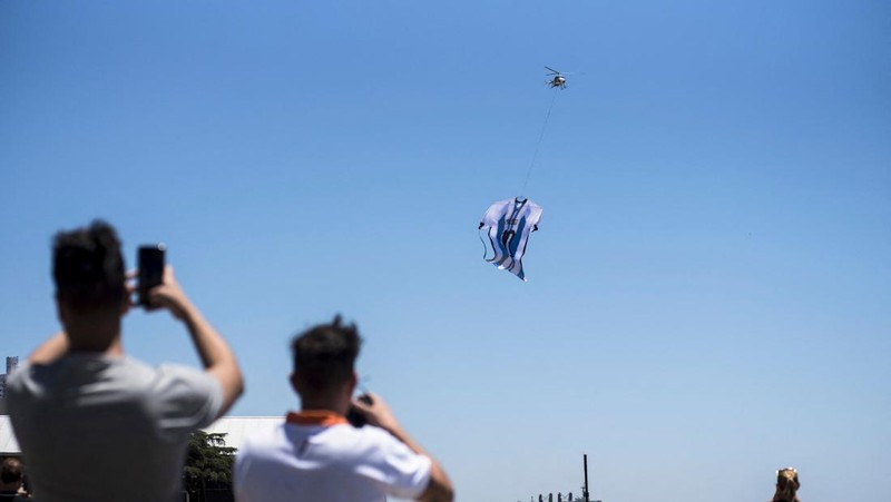 Helikopter membawa t-shirt raksasa penyerang Argentina Lionel Messi di atas Rosario, Argentina, pada 13 Desember 2022, sebelum pertandingan sepak bola semifinal Piala Dunia Qatar 2022 antara Argentina dan Kroasia. (AFP via Getty Images/STR)