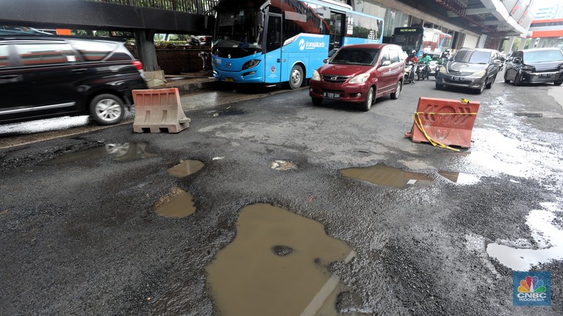 Kendaraan melintasi jalan yang rusak di kawasan HR. Rasuna Said, Kuningan, Jakarta Selatan, Rabu (14/12/2022). Sudah lama jalanan di kawasan ini berlubang dan membahayakan pengendara saat melintasinya. (CNBC Indonesia/Andrean Kristianto)