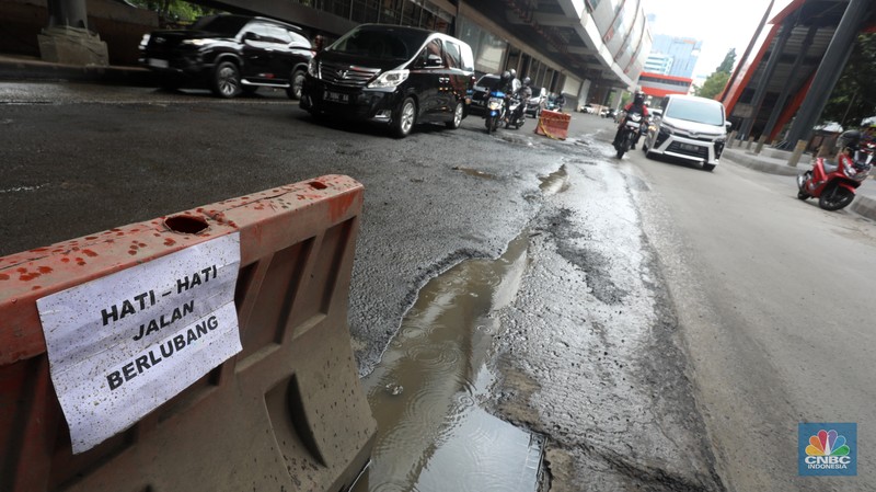Kendaraan melintasi jalan yang rusak di kawasan HR. Rasuna Said, Kuningan, Jakarta Selatan, Rabu (14/12/2022). Sudah lama jalanan di kawasan ini berlubang dan membahayakan pengendara saat melintasinya. (CNBC Indonesia/Andrean Kristianto)
