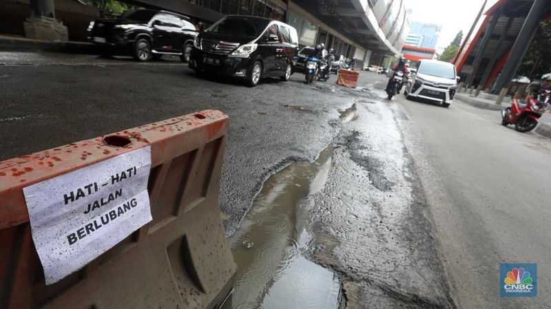Kendaraan melintasi jalan yang rusak di kawasan HR. Rasuna Said, Kuningan, Jakarta Selatan, Rabu (14/12/2022). Sudah lama jalanan di kawasan ini berlubang dan membahayakan pengendara saat melintasinya. (CNBC Indonesia/Andrean Kristianto)
