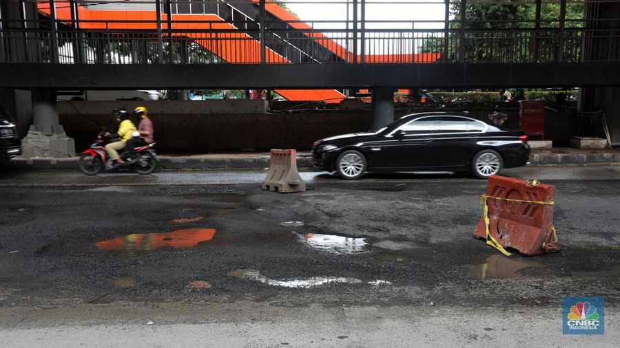 Kendaraan melintasi jalan yang rusak di kawasan HR. Rasuna Said, Kuningan, Jakarta Selatan, Rabu (14/12/2022). Sudah lama jalanan di kawasan ini berlubang dan membahayakan pengendara saat melintasinya. (CNBC Indonesia/Andrean Kristianto)