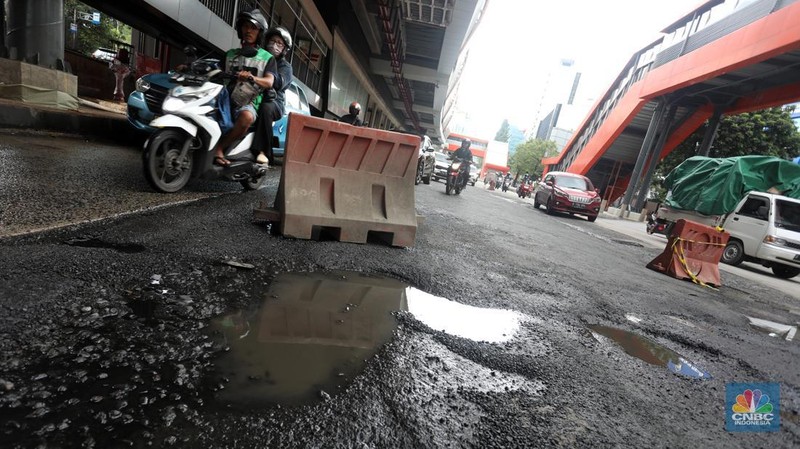 Kendaraan melintasi jalan yang rusak di kawasan HR. Rasuna Said, Kuningan, Jakarta Selatan, Rabu (14/12/2022). Sudah lama jalanan di kawasan ini berlubang dan membahayakan pengendara saat melintasinya. (CNBC Indonesia/Andrean Kristianto)