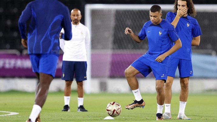 Kylian Mbappe dari Prancis mengoper bola saat Matteo Guendouzi bereaksi selama Sesi Latihan Prancis di Al Sadd SC pada 13 Desember 2022 di Doha, Qatar. (Mohamed Farag/Getty Images)