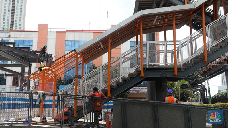 Pekerja menyelesaikan pengerjaan skywalk di kawasan Halte Velbak, Kebayoran Lama, Jakarta Selatan, Rabu (14/12/2022). Nantinya Skywalk ini dapat menghubungkan bus transjakarta koridor delapan (Lebak Bulus -Harmoni) dan koridor 13 (Ciledug-Tendean) dengan KRL Jabodetabek. (CNBC Indonesia/Andrean Kristianto)