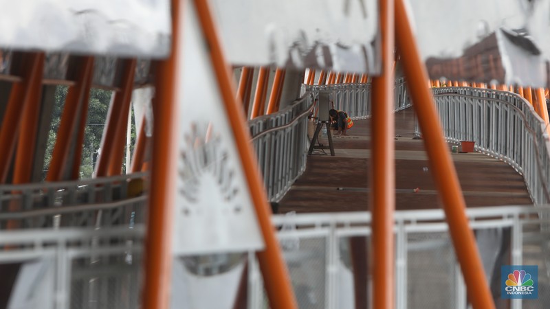 Pekerja menyelesaikan pengerjaan skywalk di kawasan Halte Velbak, Kebayoran Lama, Jakarta Selatan, Rabu (14/12/2022). Nantinya Skywalk ini dapat menghubungkan bus transjakarta koridor delapan (Lebak Bulus -Harmoni) dan koridor 13 (Ciledug-Tendean) dengan KRL Jabodetabek. (CNBC Indonesia/Andrean Kristianto)