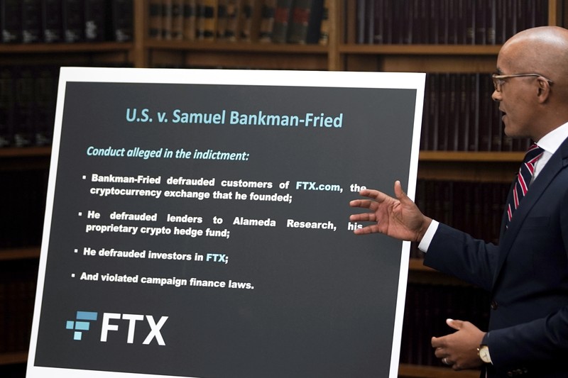 Sam Bankman-Fried, yang mendirikan dan memimpin FTX sampai krisis likuiditas memaksa pertukaran cryptocurrency untuk menyatakan kebangkrutan, dikawal keluar dari gedung Pengadilan Magistrate setelah penangkapannya, di Nassau, Bahamas 13 Desember 2022. (REUTERS/DANTE CARRER)