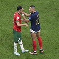 Kylian Mbappe dari Prancis dan Achraf Hakimi dari Maroko saling menyapa setelah Prancis memenangkan pertandingan semifinal Piala Dunia FIFA Qatar 2022 melawan Maroko di Stadion Al Bayt pada 14 Desember 2022 di Al Khor, Qatar. Prancis mengalahkan Maro