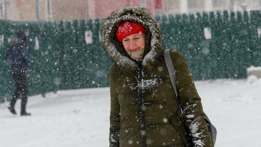 Seorang pria membersihkan salju saat hujan salju di Kyiv, Ukraina pada 15 Desember 2022. (Anadolu Agency via Getty Images)