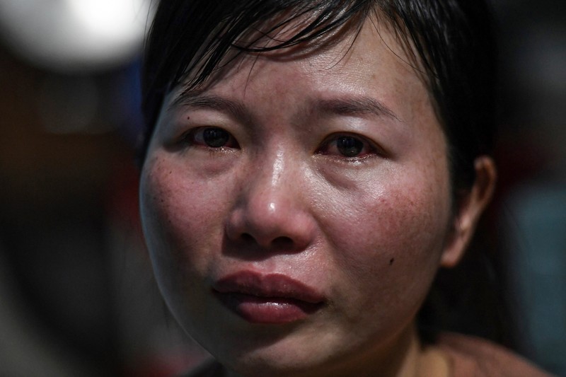 Para pekerja berpamitan kepada pemimpin mereka pada hari terakhir mereka bekerja di pabrik Taiwan Ty Hung di Kota Ho Chi Minh, Taiwan.  (AFP via Getty Images/NHAC NGUYEN)