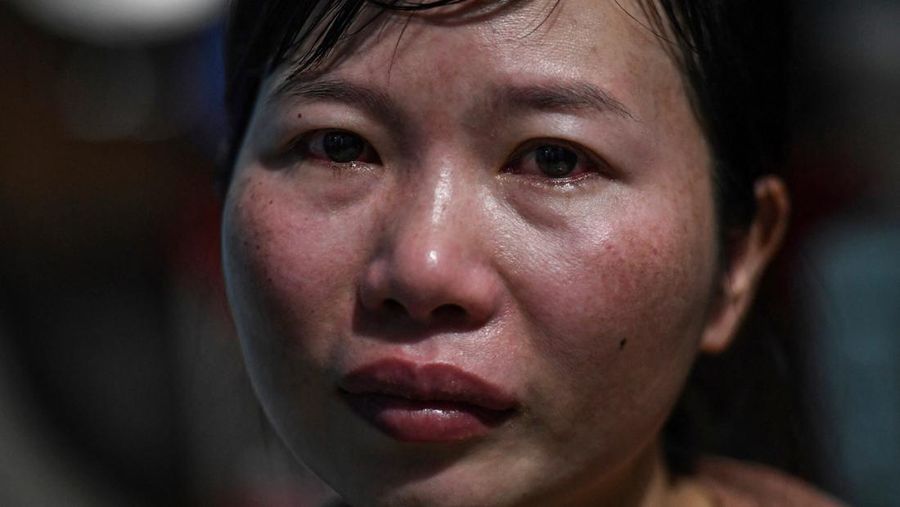Para pekerja berpamitan kepada pemimpin mereka pada hari terakhir mereka bekerja di pabrik Taiwan Ty Hung di Kota Ho Chi Minh, Taiwan.  (AFP via Getty Images/NHAC NGUYEN)